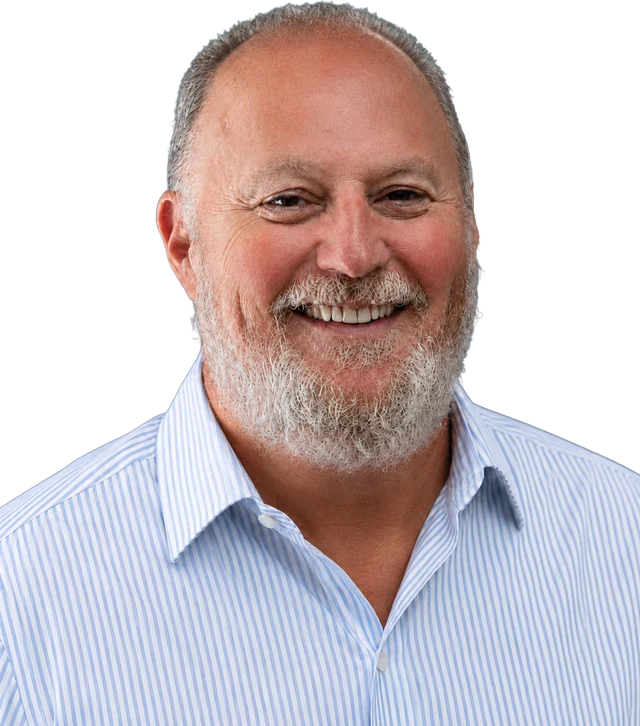 Paul Lange, smiling, in an open-collar striped shirt.